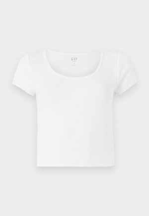 Fehér, rövid ujjú, cropped pamut póló, kerek nyakkivágással, egyszerű, mintázat és díszítés nélküli kivitelben.