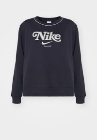 Marinblå sweatshirt i bomull med en stor vit "Nike"-logotyp med en böjd design och texten "Sedan 1972" nedanför. Långa ärmar, ribbade muddar.