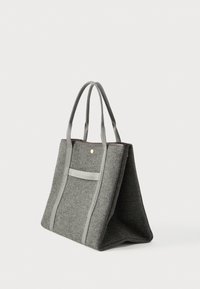 Γκρίζα τσάντα φορέματος από ύφασμα με διπλές λαβές, εξωτερική τσέπη και δομημένη ορθογώνια βάση, εμφανιζόμενη σε απαλό ανοιχτό φόντο.