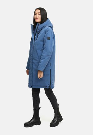 Blauwe lange parka jas met een capuchon, voorzien van een frontrits, zijzakken en een logopatch op de mouw. Draag het met zwarte skinny jeans en laarzen.