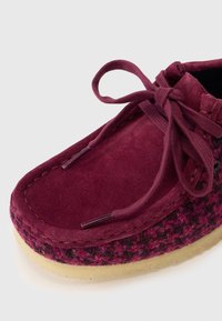 Shoe din velur cărămiziu cu accente din țesătură împletită, bot rotund și șireturi asortate. Prezintă o talpă din cauciuc de culoare deschisă și cusături decorative.