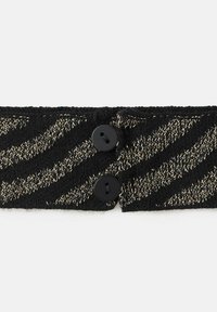 Čierny pletený obväz na hlavu s prevažne zlatým zigzagovým vzorom, upevnený dvomi čiernymi gombíkmi na jednej strane. Mäkka textúra a flexibilný dizajn.