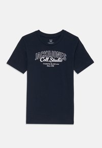 Tamsiai mėlyna medvilninė trumpomis rankovėmis marškinėliai su balta tekstine spauda: "JACK&JONES Coll. Studio Sukūrė [Jc] komanda nuo 1990."