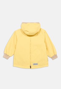 Κίτρινο μπουφάν με κουκούλα, ελαστικά μανίκια και κλείσιμο με φερμουάρ. Λείος, ελαφρύς ύφασμα· διαθέτει μια μικρή ετικέτα κοντά στο τελείωμα.
