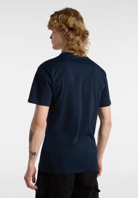 Námořnická modrá bavlněná tričko s kulatým výstřihem, krátkými rukávy a hladkou texturou, s jednobarevným zadním dílem a bez viditelných log nebo grafik.