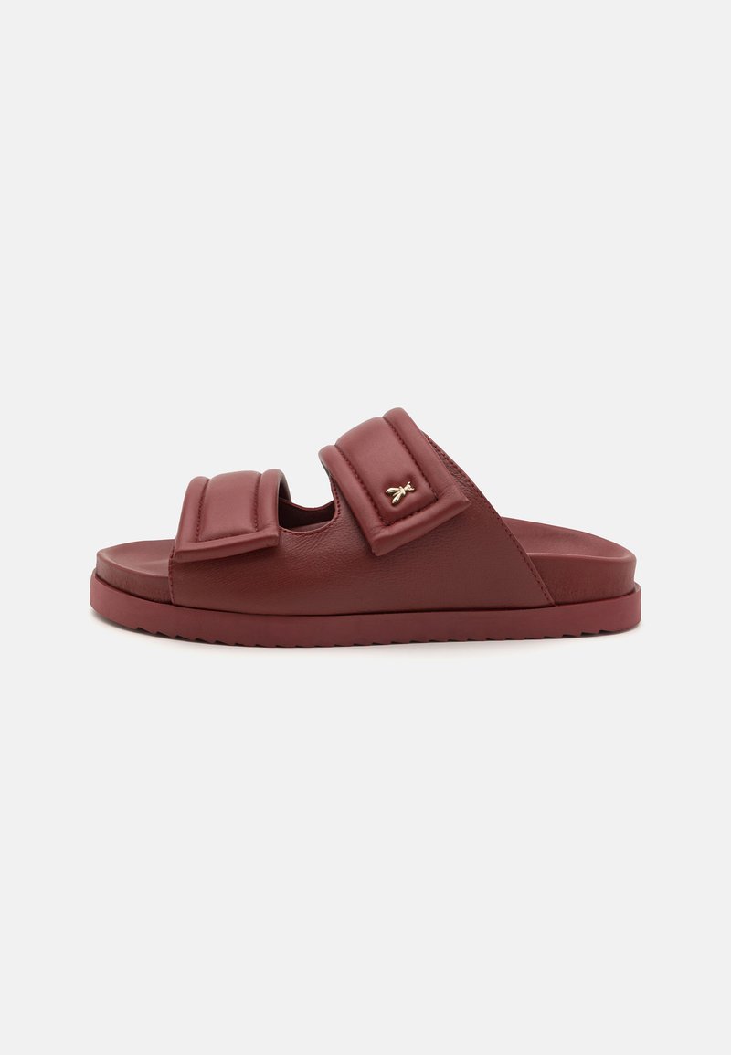 Bordeaux fargete sandaler med to polstrede stropper, teksturert overflate og en subtil gull-logo aksent på den ytre stroppen. Flat sålekonstruksjon.