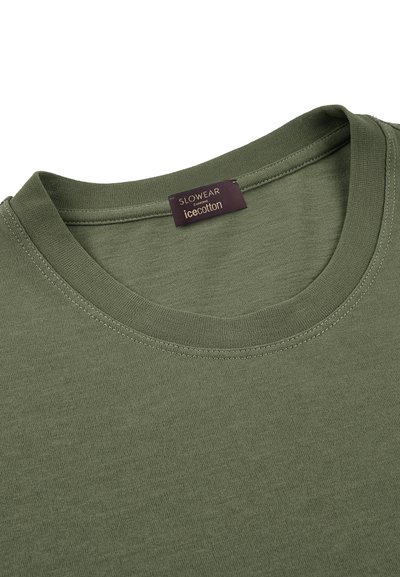 Camiseta de algodón verde olivo con un cuello redondo, detalles de costura sutiles y una etiqueta que dice "SLOWEAR icecotton" en el interior del cuello.