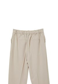 Pantaloni beige con vita elastica e pieghe, dotati di due tasche laterali e un tessuto leggero e morbido. Sul retro ci sono due tasche cucite.