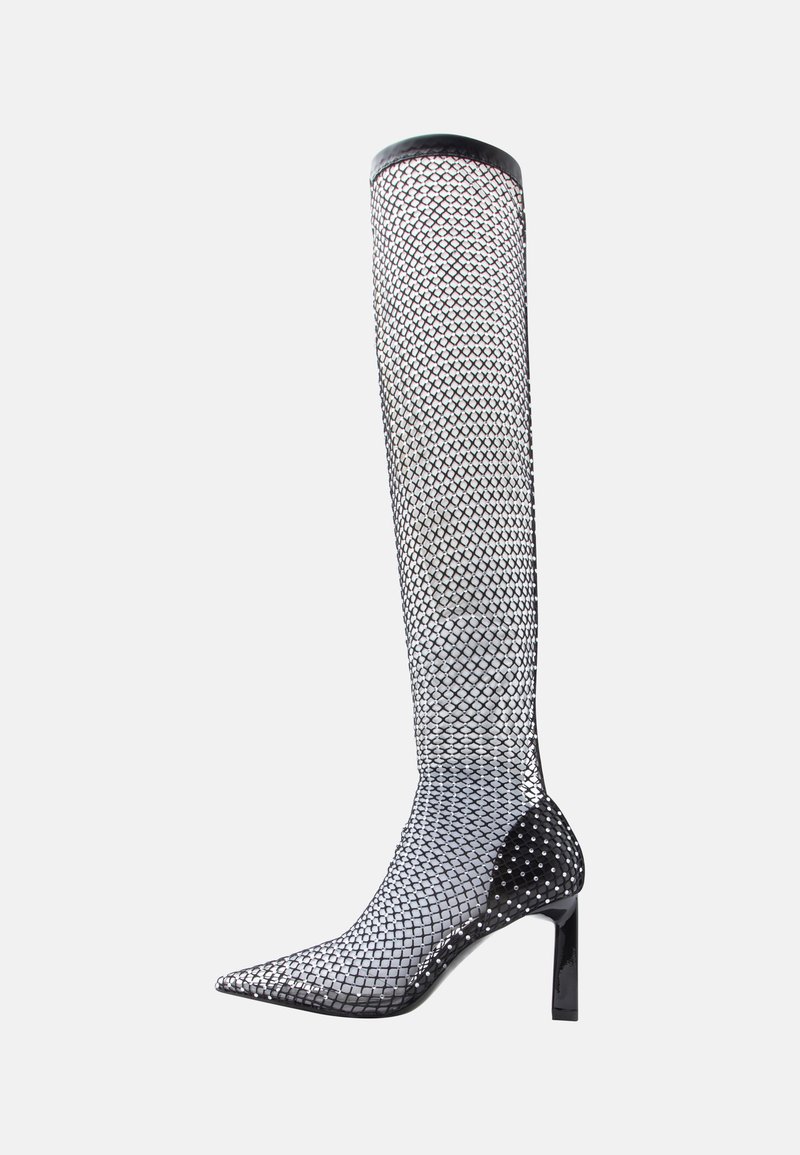 Μαύρη ψηλότατη μπότα με δίχτυ δίχτυ και μυτερή μύτη, λεπτομερειές με λαμπερά στοιχεία και γυαλιστερό μαύρο τακούνι. Διαθέτει κομψό, υφασμένο σχέδιο.