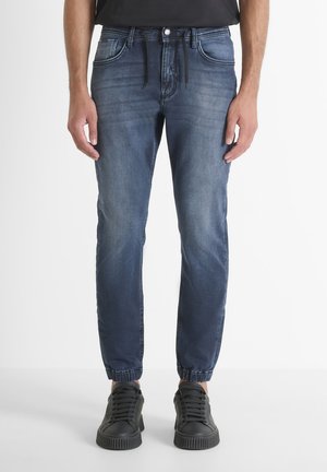 Men's jogger jeans in dark blue denim. Features elasticized cuffs, multiple pockets, and a drawstring waist for adjustable fit.