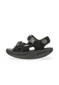 Sandalias negras con parte superior de material sintético y recortes, correas ajustables y una suela negra gruesa y texturizada para mayor estabilidad.