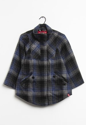 Manteau en laine à carreaux bleu, noir et gris avec col montant, manches longues, rabat avant et deux poches boutonnées sur un cintre noir.