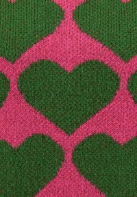 Pattern di cuori verdi lavorati a maglia su uno sfondo di tessuto rosa lavorato a maglia, creando un design geometrico ripetitivo.
