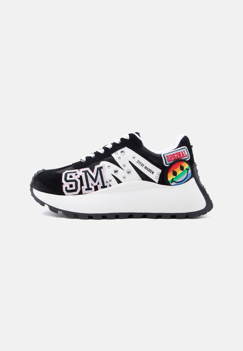 Baskets noires et blanches avec les lettres "SM", des clous, le texte "Steve Madden" et un patch smiley arc-en-ciel avec l'étiquette "Original" sur le talon.