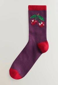 Lilla sok med rød kant og tå. Har broderede røde kirsebær med hvide detaljer og grønne blade på oversiden.