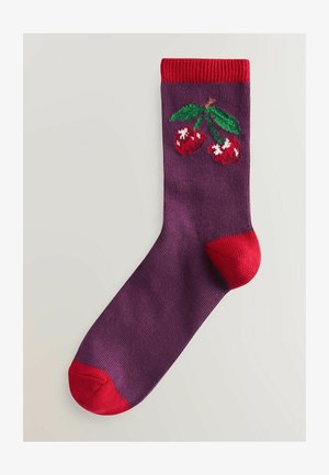 Lila Socke mit rotem Bündchen und roter Spitze. Auf der Oberseite sind rote Kirschen mit weißen Akzenten und grünen Blättern gestickt.