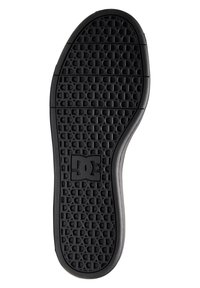 Sól skate topánky DC s textúrovanou čiernou gumou, obsahujúca mriežkový vzor a logo. Zaoblený prst a bočný dizajn pre trakciu.