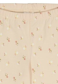 Leggings rosa chiaro in un tessuto morbido e elasticizzato, con un motivo floreale sparso in bianco, giallo e rosso. Includono una cintura elastica.
