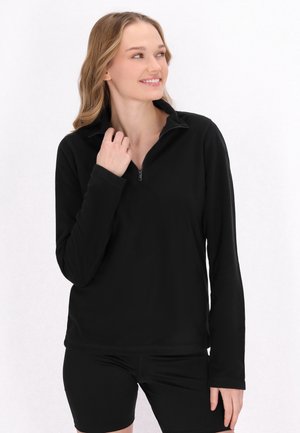 Sort fleece pullover med halv lynlås, lange ærmer og en blød tekstur. Bæres med sorte shorts, der har et klassisk kravedesign.