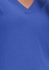 V-hals pullover in helder blauw, gemaakt van zacht, glad stof. Heeft ribgebreide randen en een aansluitende pasvorm, met een uniforme textuur.