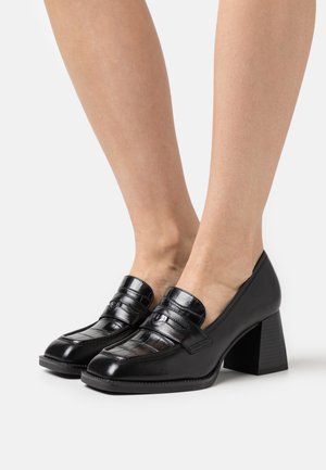 Mocassins en cuir noir avec une finition brillante, présentant un motif crocodile, un embout rond et un talon block moyen.