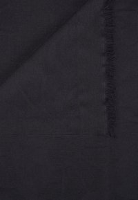 Tissu sombre avec un motif subtil, surface texturée et bords frangés, affichant une couleur noire profonde tout au long.