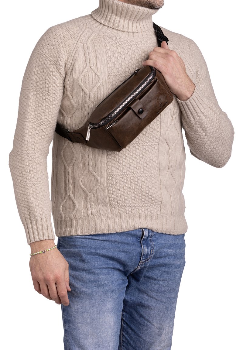 Marsupio in pelle marrone con tasca anteriore con zip e chiusura a scatto, indossato a tracolla. Il marsupio ha un design elegante e minimalista e una tracolla regolabile.