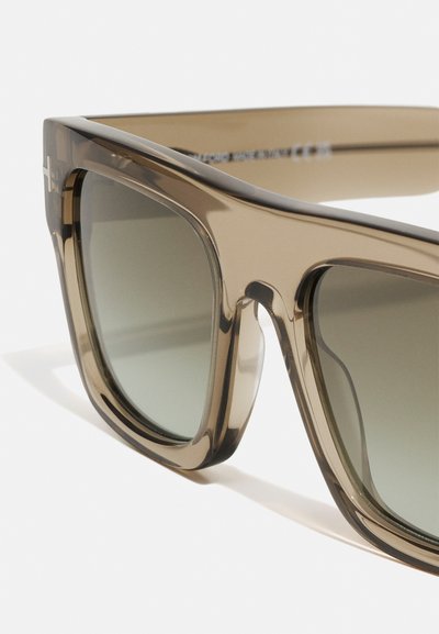 Ochelari de soare cu rame supradimensionate, unghiulare, de culoare maro. Lentile de un verde închis, cu o finisare netedă și lucioasă, și detalii hardware minime.