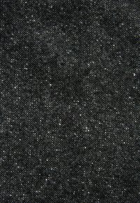 Tejido de color gris oscuro con una superficie texturizada, que presenta un sutil patrón moteado. Los hilos están tejidos de manera ajustada, creando una apariencia duradera.