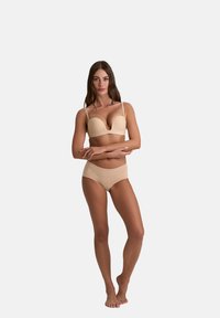 Beige naadloze bh met een diepe V-hals en verstelbare bandjes, in combinatie met bijpassende hoge taille slips, beide in een gladde stof.