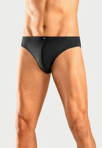 Schwarze Herrenunterhose mit glatter Textur, tailliertem Design und elastischem Bund mit Logo. Schlichte und klassische Silhouette.