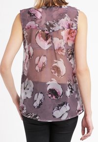 Top senza maniche in tessuto trasparente con design floreale in tonalità di rosa e viola, con orlo arrotondato e texture sottile. Vista posteriore mostrata.