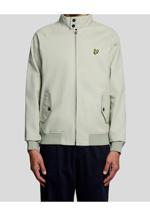 Veste zippée gris clair avec col montant, deux poches avant à boutons et un petit logo oiseau jaune sur la poitrine gauche.