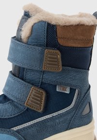 Blauwe enkelboot met een combinatie van textuurleer en mesh, twee verstelbare banden, een bruin suède accent en een zachte faux fur voering.
