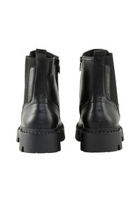 Bottes de cheville en cuir noir avec des panneaux élastiques sur les côtés et une semelle en caoutchouc texturé. Comprend une fermeture éclair à l'arrière et des détails cousus.