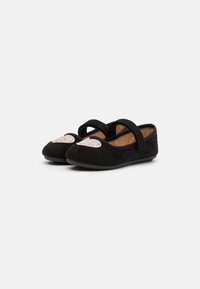Ballerine in suede nero con due fasce in velcro, dotate di un dettagli di un cuore argento scintillante sulla punta e una suola nera flessibile.