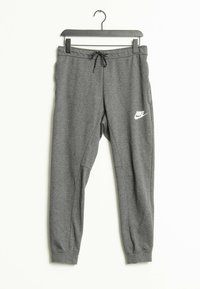 Grå Nike sweatpants med elastiska muddar och dragsko i midjan hängande på en svart galge mot en vit bakgrund.