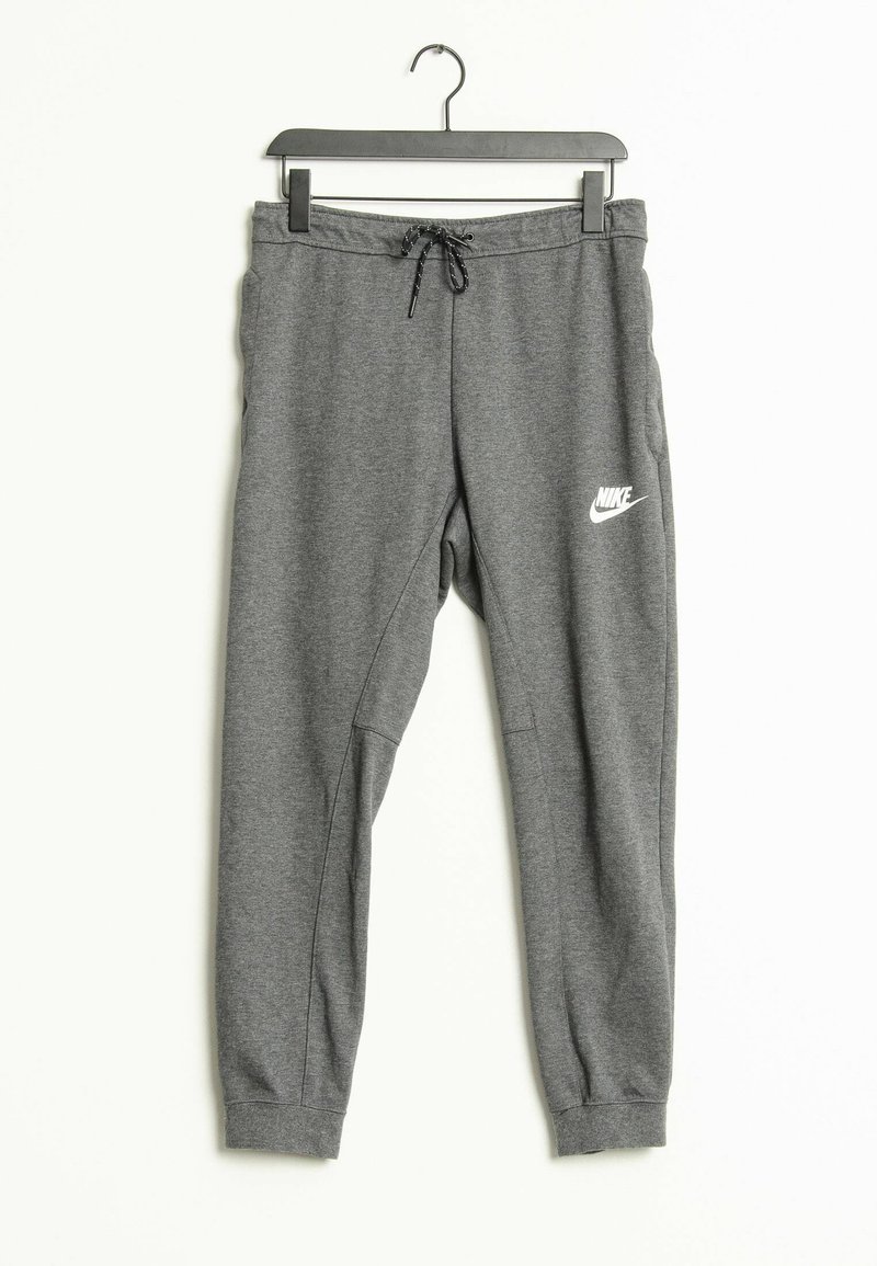 Grå Nike sweatpants med elastiska muddar och dragsko i midjan hängande på en svart galge mot en vit bakgrund.