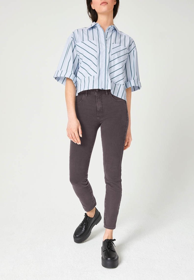 Lichtblauw gestreept cropped shirt met korte mouwen, gecombineerd met donkere grijze skinny jeans en zwarte platform schoenen.
