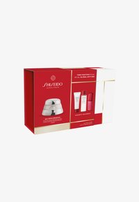 Shiseido gave-set med en rød boks, som inneholder en sølv kremkrukke og tre små produktflasker i rødt og hvitt. Tekst fremhevet.