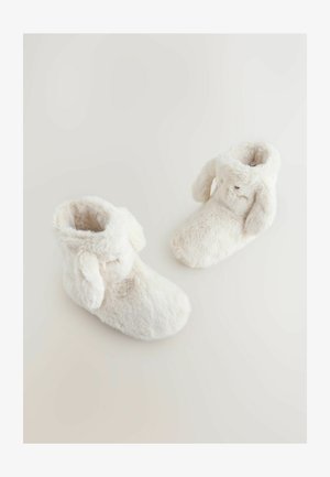 Stivaletti pelosi bianchi con una texture morbida e punta arrotondata, dotati di accenti a forma di orecchie flosce e un interno accogliente e imbottito per il calore.