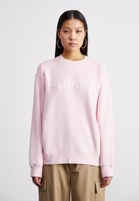 Felpa rosa in cotone, con collo tondo, maniche lunghe e logo "carhartt" ricamato in un colore a contrasto.