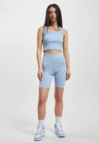 Světle modrý žebrovaný crop top a odpovídající cyklistické šortky vyrobené z elastického materiálu. Obsahuje bezešvý design a zaoblený výstřih.