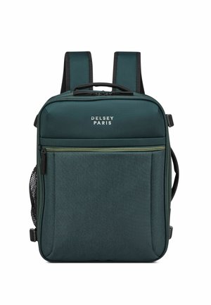 Delsey Paris backpack in dark green fabric with two shoulder straps, front zip pocket, and side mesh pocket. Subtle logo on the front.