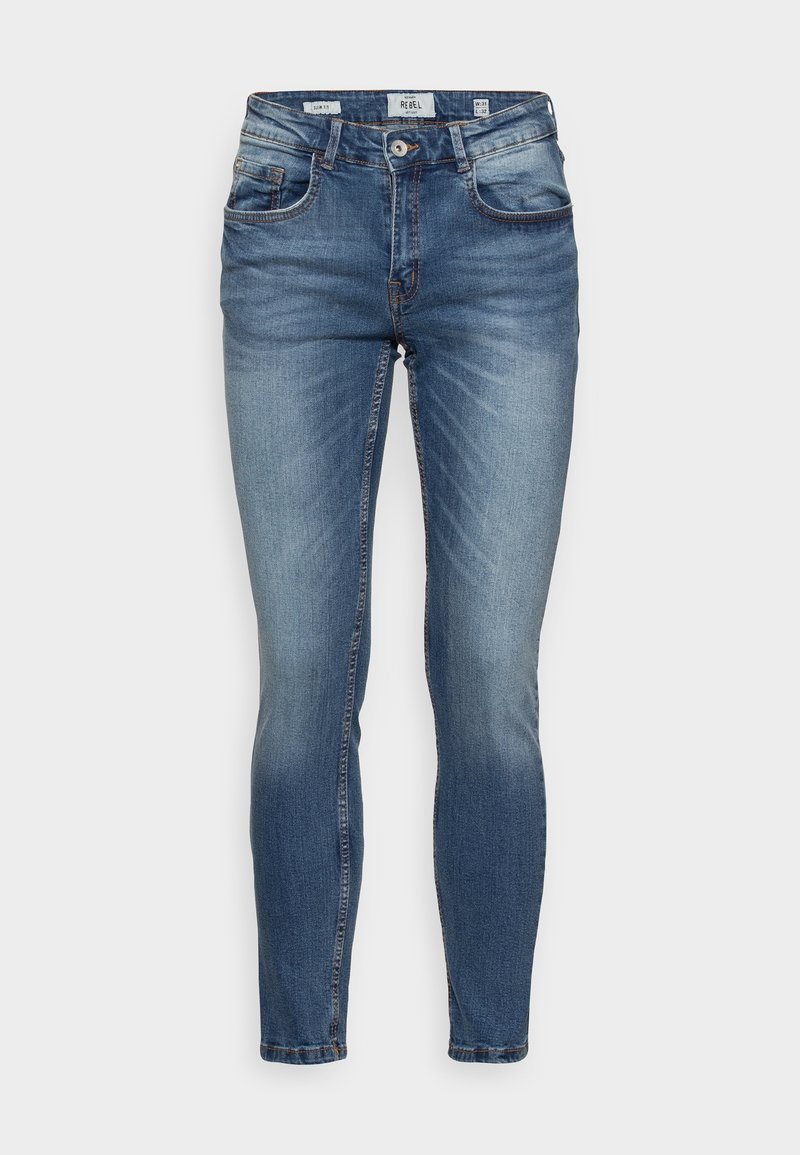 Jean slim bleu en denim avec bouton et fermeture éclair à l'avant, poches avant et arrière, et détails délavés.