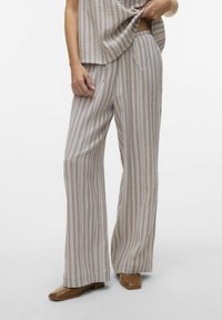 Pantalons larges légers à rayures en tissu doux, présentant des teintes beige, rose pastel et crème. Coupe décontractée avec une taille confortable.