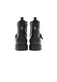 Botas de cuero negro con puntera redondeada, detalles acolchados, cremalleras laterales y acentos de logo en relieve en la parte posterior y los lados. Suelas gruesas.