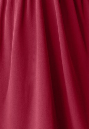 Roter Stoff mit einer glatten Textur, der einen subtilen Glanz aufweist. Das Material hat ein leicht drapiertes Aussehen und zeigt sanfte Falten und Knicke.