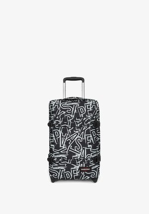 Valise à roulettes noire et blanche avec motif abstrait de lettres superposées et poignée télescopique déployée, logo Eastpak visible sur le devant.