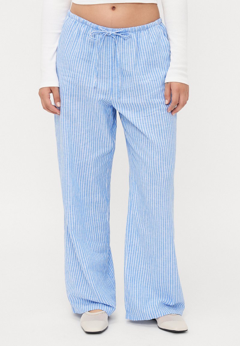 Calças largas listradas em azul claro, com cintura elástica. Feitas de um tecido suave, apresentam listras verticais brancas e um corte descontraído.